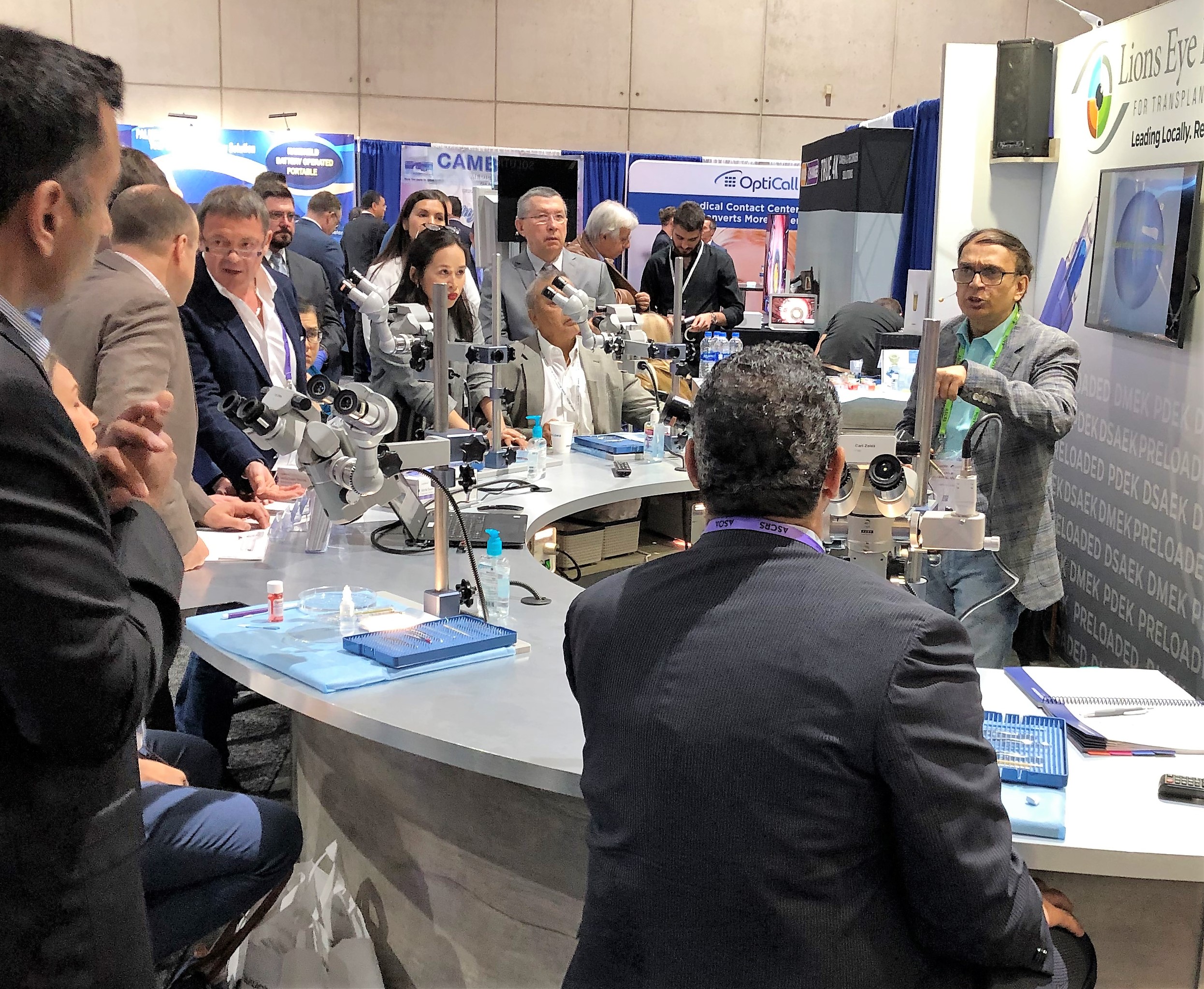 surgeon presenting to other surgeons on exhibit floor of convention